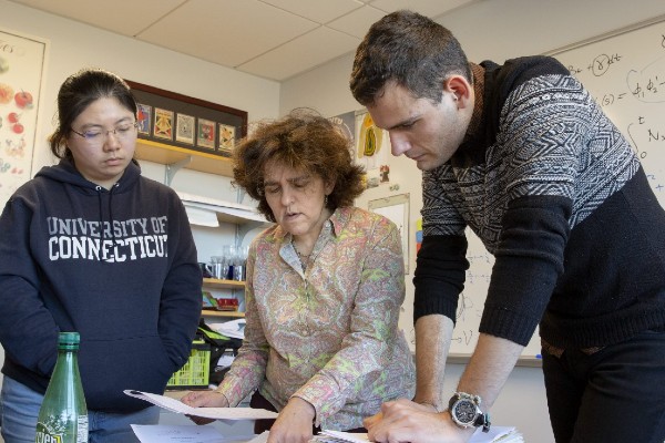 Math professor working with students at a desk.